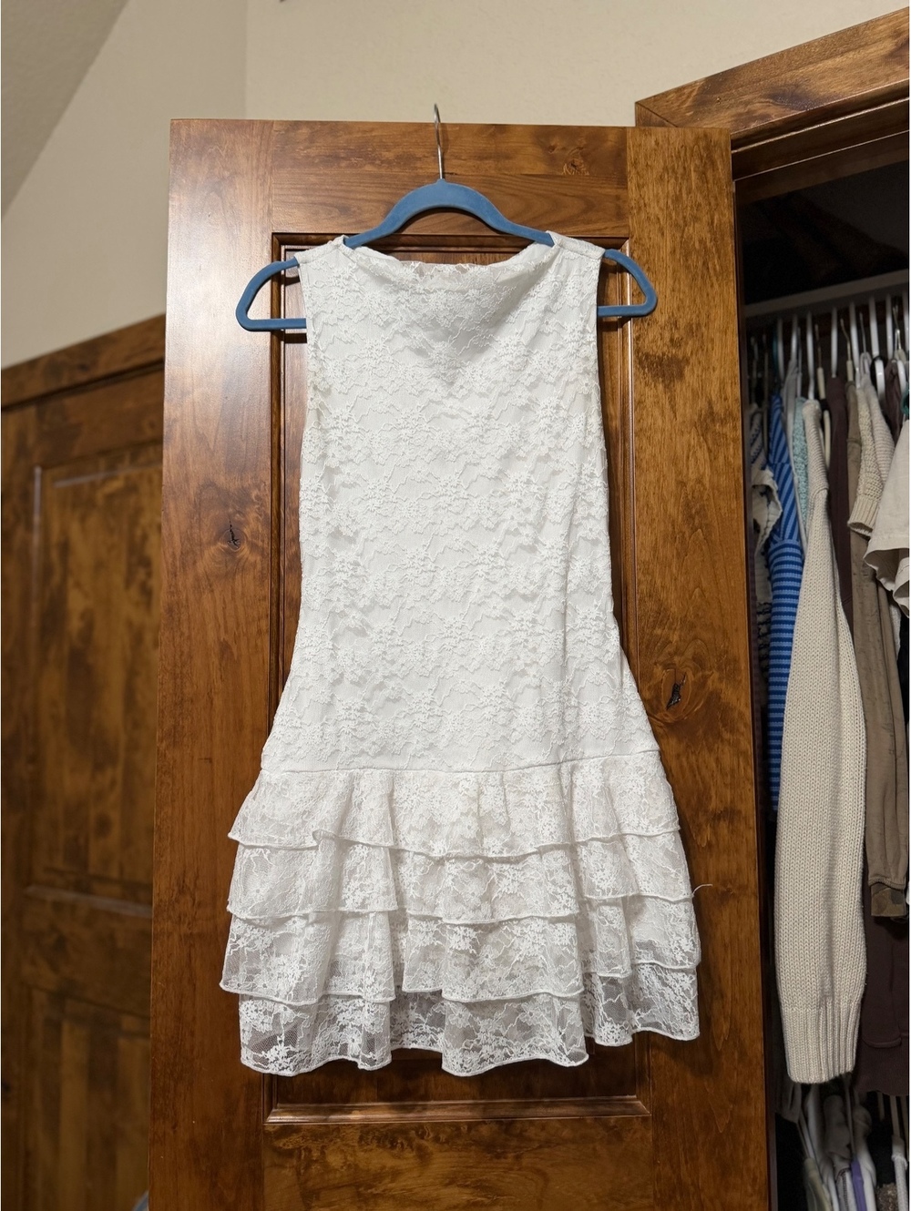 sleeveless white lace mini dress featuring a tiered ruffled hem.